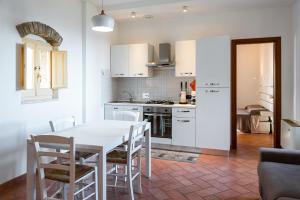 a kitchen with a white table and white cabinets at Casa vacanze frate Elia - A 50 mt dalla Basilica di San Francesco in Assisi