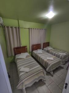 3 camas en una habitación con paredes verdes en Hotel Maichel, en Erval Velho