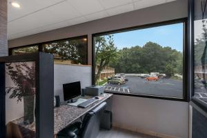 ein Büro mit einem Schreibtisch mit einem Computer und einem Fenster in der Unterkunft Quality Inn Westfield - Springfield in Westfield