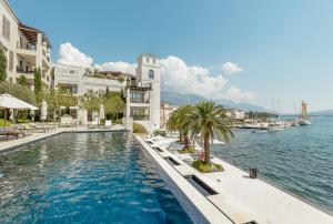 een zwembad voor een gebouw naast het water bij Porto Montenegro in Tivat