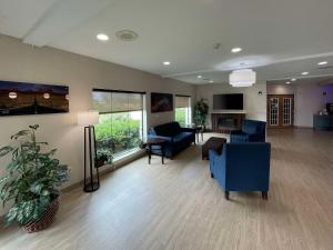 een grote woonkamer met blauwe stoelen en een bank bij Comfort Suites Near Seaworld in San Antonio