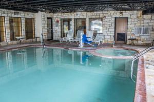 a large swimming pool with chairs and a table at Comfort Suites Near Seaworld in San Antonio