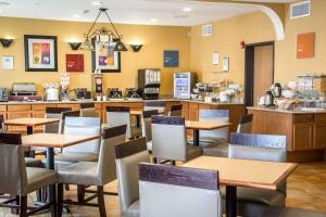 a restaurant with tables and chairs and a counter at Comfort Suites Near Seaworld in San Antonio