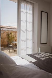 1 dormitorio con 1 cama y ventana con mesa en Villa Ernie en Saint-Martin-de-Ré