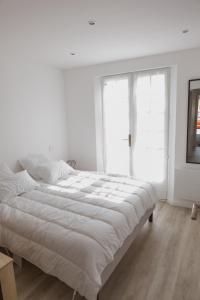 ein weißes Schlafzimmer mit einem großen Bett und einem Fenster in der Unterkunft Villa Ernie in Saint-Martin-de-Ré + 13 Fotos