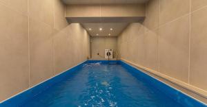 a indoor swimming pool with blue water in a room at Hwangridan Stay in Gyeongju