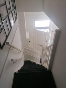 une vue de tête sur un escalier avec un tapis noir dans l'établissement Casa Elburg, à Elburg