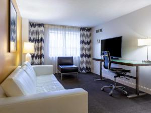 Habitación de hotel con sofá y escritorio con ordenador. en Comfort Inn & Suites Baltimore Inner Harbor en Baltimore
