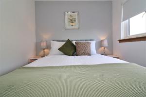 a bedroom with a large bed with a green blanket at Signature - Moore View in Hamilton