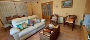 sala de estar con sofá blanco y sillas en Casa Rural Rincones de Albares, en Albares