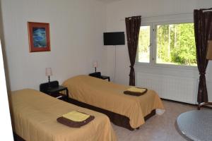 a hotel room with two beds and a window at Hostelli Kuninkaankartano in Kuninkaanlähde +22 photos