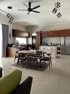 sala de estar con mesa y cocina en Homestay Fe-feeling Artis with 4 Bedrooms, en Rawang