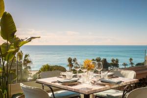 een eettafel met uitzicht op de oceaan bij Anantara Plaza Nice Hotel - A Leading Hotel of the World in Nice
