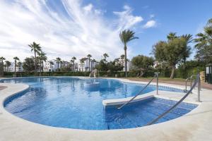 a swimming pool in a resort with palm trees at Corazon de Tarifa in Zahara de los Atunes