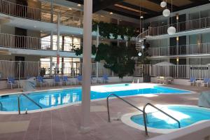 uma grande piscina num grande edifício com cadeiras e mesas em Quality Inn West Lafayette - University Area em Lafayette