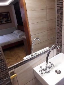 baño con lavabo, espejo y cama en Vila Zlatibor en Zlatibor