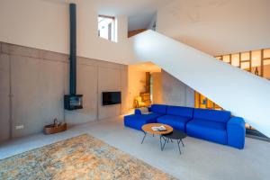sala de estar con sofá azul y mesa en Haus Moosberg - Erholung bei Seeblick und Ruhe, en Gmunden