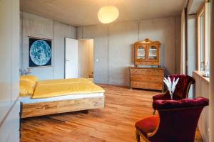 1 dormitorio con 1 cama, vestidor y silla en Haus Moosberg - Erholung bei Seeblick und Ruhe, en Gmunden