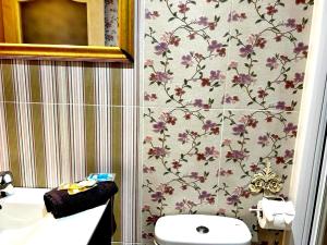 baño con aseo y papel pintado de flores en Holibai, Vermello, Un rincón con encanto cerca de la playa, en Baiona 18 fotos más