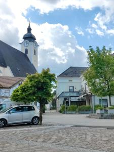 a car parked in front of a building with a clock tower at Neuhof in Neuhofen an der Ybbs