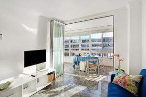 un soggiorno con divano blu e TV di B - M Playa a Playa del Aguila