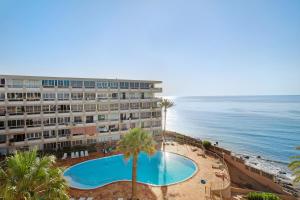 un hôtel avec une piscine à côté de l'océan dans l'établissement B - M Playa, à Playa del Aguila