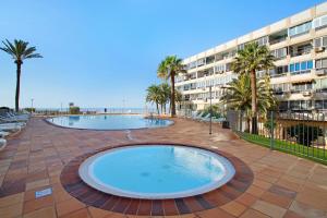 una grande piscina di fronte a un edificio di B - M Playa a Playa del Aguila