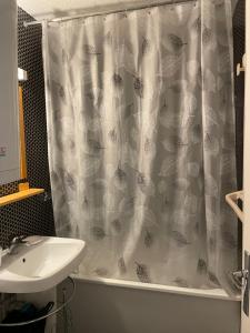 a bathroom with a sink and a shower curtain at Appartement pour 6 personnes au pied des pistes au calme aux Menuires les Asters in Les Menuires +31 photos