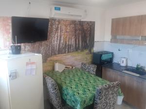 a small kitchen with a table and a refrigerator at NUESTRO MUNDO TRELEW in Trelew