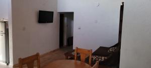 ein Wohnzimmer mit einem Tisch und einem TV an der Wand in der Unterkunft Cabaña Los Reartes in Los Reartes