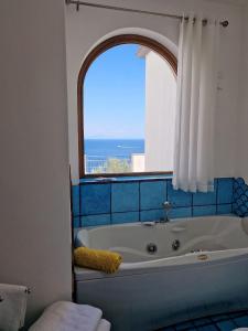 a bath tub in a bathroom with a window at HOLIDAY double in Praiano