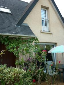 Una casa con un montón de plantas delante de ella. en Chambre chez l'habitant vue sur jardin, parking, en Le Rheu