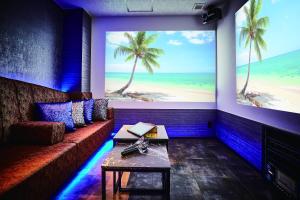 a room with a couch and a large picture of the beach at Petit Bali Ikebukuro in Tokyo