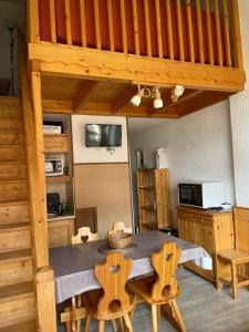 a kitchen with a table and chairs in a room at Appartement pour 6 personnes au pied des pistes au calme aux Menuires les Asters in Les Menuires