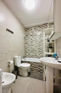 ein Badezimmer mit einem WC, einem Waschbecken und einer Badewanne in der Unterkunft Seguro El Sol 411 in Puerto de Santiago