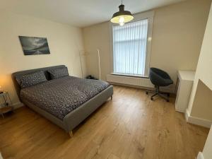1 dormitorio con cama, escritorio y silla en Big 1 Bedroom London House 2 bathroom, en Plumstead