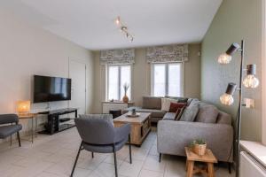 uma sala de estar com um sofá e uma televisão em Villa Bakboord em Oostende