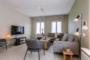 a living room with a couch and a tv at Villa Bakboord in Ostend