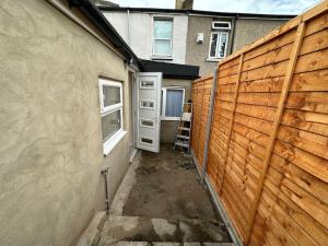 a building with a fence and a ladder next to a door at Big 1 Bedroom London House 2 bathroom in Plumstead