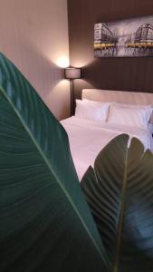 a bedroom with a bed with a large green leaf at D' Pines -Family Suite in Melaka