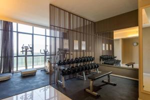 a gym with rows of exercise equipment and a large window at D' Pines -Family Suite in Melaka