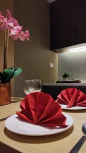 a table with two red napkins on a table at D' Pines -Family Suite in Melaka