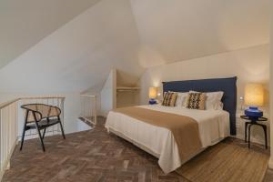 1 dormitorio con 1 cama grande y 1 silla en Silves History Guest House en Silves