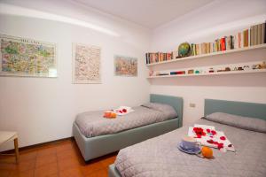 メナッジョにあるMenaggio Poggio Fiorito Loggettaのベッドルーム1室(ベッド2台、テーブル、カップ付)