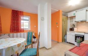 um quarto com uma mesa e uma cozinha com paredes cor de laranja em Holiday apartment in Razanj with terrace, air conditioning, WiFi, washing machine 4773-1 em Razanj