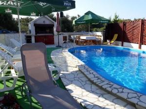 uma piscina com cadeiras e guarda-sóis ao lado em Holiday apartment in Razanj with terrace, air conditioning, WiFi, washing machine 4773-1 em Razanj