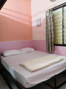 a bed in a room with a window at Hua Tang Homestay in Ipoh