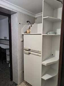 a white closet with white shelves in a room at La casa del Viajero in Puertollano