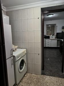 a kitchen with a washing machine in a room at La casa del Viajero in Puertollano