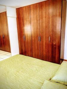 a bedroom with a bed and wooden cabinets at Lago Norte - CA 05 in Brasilia
